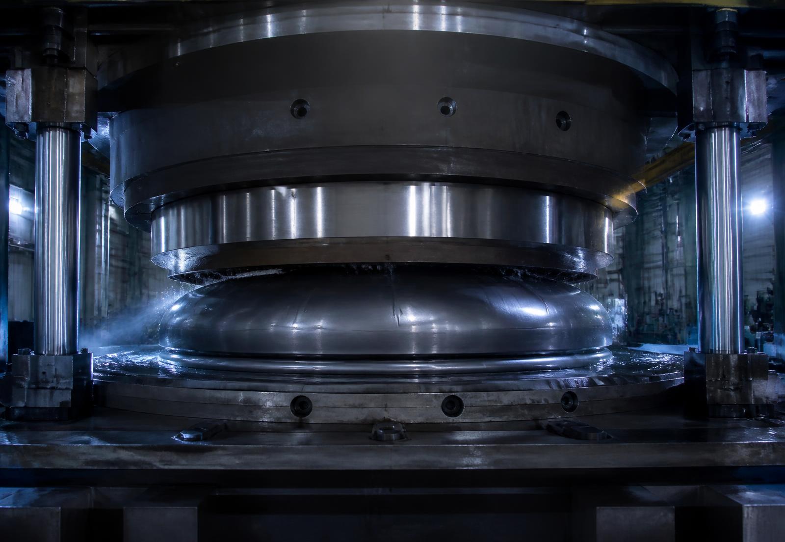 Prensa de hidroconformado dando forma a un fondo metálico para tanque industrial